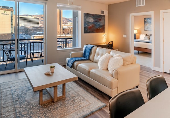 Beautifully designed living room. 75" TV. Electric fireplace. Leather sofa and amazing views of mountains and city skyline.