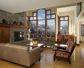 In The Mountainside House's living room, elegant custom furniture and unobstructed Killington Mountain views create a sophisticated ambiance.
