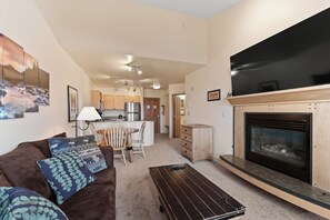 Living area with a mounted TV above a gas fireplace, and queen size sleeper sofa.