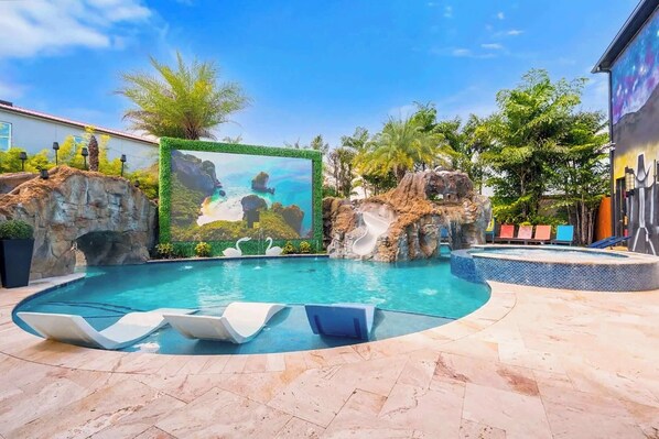 The pool area features an oversized double-sided screen to watch all your fav movies.