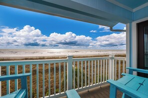 The fantastic oceanfront view from our patio, with four wood adirondack chairs.