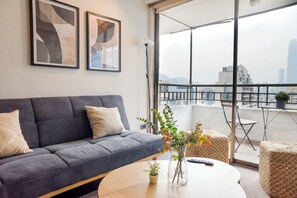 Relax in this cozy living room with a stunning balcony view, perfect for enjoying Santiago's skyline.