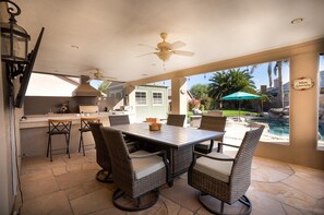 The covered bar area includes a built in bbq, refrigerator and pizza oven as well as ample outdoor seating 