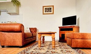Living area, comfy sofa, smart TV & coffee table.
