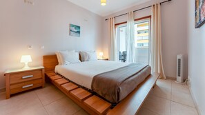 A tranquil bedroom with a comfortable double bed, natural light, and a private balcony is ideal for a restful stay. #SweetDreams #RelaxAndRecharge