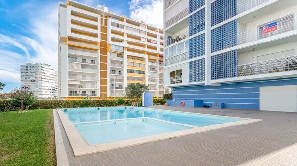 Relax and unwind by the inviting shared pool, surrounded by a well-maintained garden and vibrant architecture. #VacationMode #PoolsideVibes