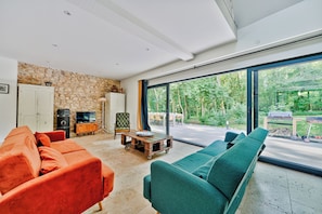 Coin salon cosy avec 2 canapés convertibles, jeux de société & vue sur le jardin