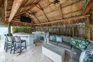 Tiki hut with outdoor grill, covered seating and bar