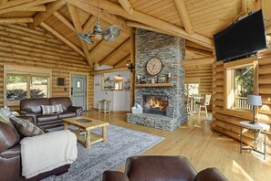 Double sided wood-burning fireplace for your comfort, dividing the living room from dining room and kitchen