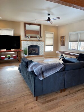 Main living room with huge sectional,  amazing shuffleboard table and large TV