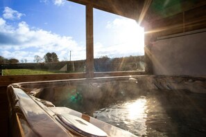Hot tub with steam coming off it and views over the fields