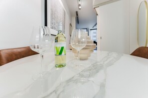 Elegant dining setup featuring a marble-top table, with a bottle of wine or a Sauvignon Blanc, it's a perfect cozy evening.