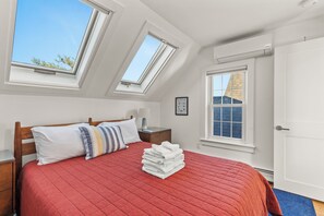 Unwind in the spacious primary bedroom, featuring a comfortable bed.