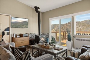 Immerse yourself in the stunning mountain vistas or relax with your preferred shows on the Smart TV. A desk situated nearby offers a serene workspace.