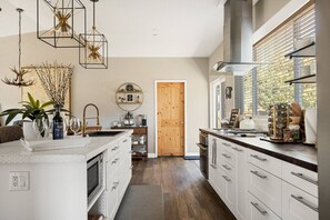 The scent of freshly brewed coffee fills the air as you step into the modern, sleek fully equipped kitchen.