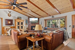 An open-concept living room that is cozy and features a gas fireplace.