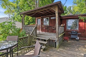 The Tree House - Deck Overlooking Lake - Relax on the spacious covered deck, perfect for outdoor dining and lounging while taking in views of Conesus Lake. This charming lakefront cabin offers a quiet retreat, just steps away from the water for endless out