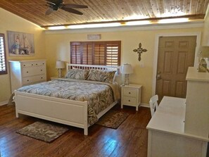 This spacious bedroom features a Tempur-Pedic King bed, a dedicated work desk, and a flatscreen TV. With vaulted ceilings and serene décor, it's perfect for both relaxation and productivity during your stay.