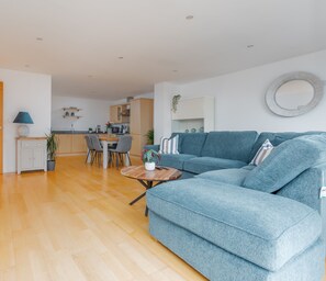 The living room connects to the modern kitchen with full range of appliances