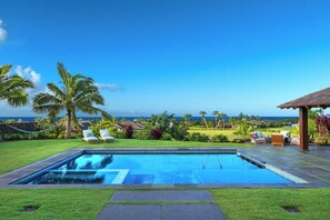 Dive into relaxation with the sparkling pool surrounded by lush greenery.