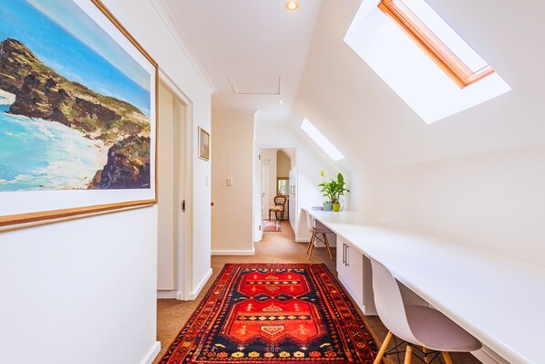 Passage way with long working desk and chairs.