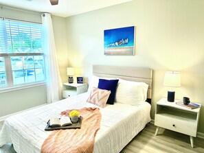 Bedroom overlooking pool, queen bed, 2 night stands