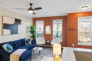 Bright living space with sectional sofa, 50" smart TV, and hardwood floors.