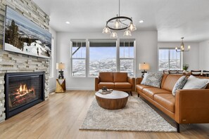 Living room on main floor off kitchen with fireplace, TV, and amazing views