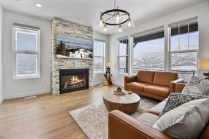 Living room on main floor off kitchen with fireplace, TV, and amazing views