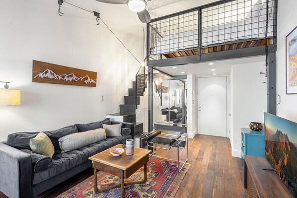 Spacious studio with Queen bed, closet for storage, high ceilings, and modern style.