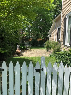 Fully fenced in yard with small patio and fire pit.