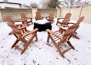 huge fire pit with grilling grates.  8 adirondack chairs. Roasting sticks avail.