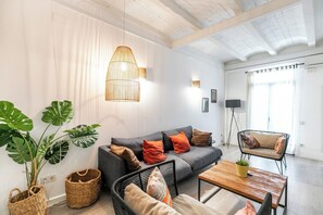 De estilo boho, la sala de estar tiene muebles cómodos y salida al balcón