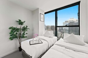A second bedroom with a 2 single beds & plush pillows.