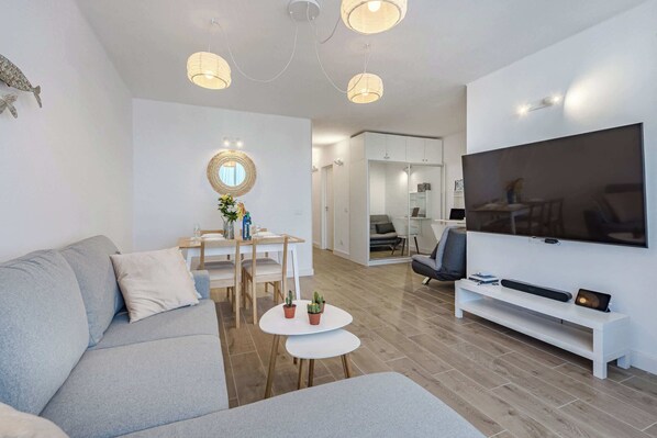 Living Room with Sofa Bed, TV, Air Conditioner, Sound System, iPad and Dining Table