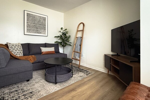You feel a sense of peace as you step into the living room , with its inviting decor and soothing tones.