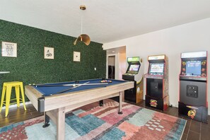 Game room - Pool table, arcade machines, and seating 