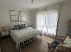 Master bedroom with queen bed, bedside tables, clothes storage & blockout blinds