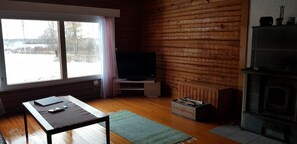 Living room with wood burning fireplace and TV