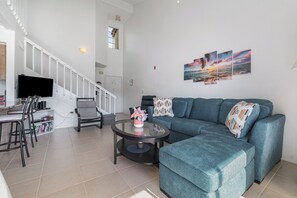 Gather in the inviting living space with plush seating and modern decor, ideal for movie nights or unwinding after a day of exploring. Bright and airy with natural light.