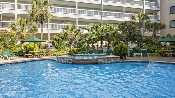 Relax in the hot tub or pool with loungers nearby.