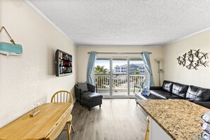 Spacious living area with natural light and balcony access.