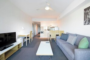 The open plan living, dining and kitchen area is flooded with natural light. It features a dedicated workspace, ideal for travelling on business.  
