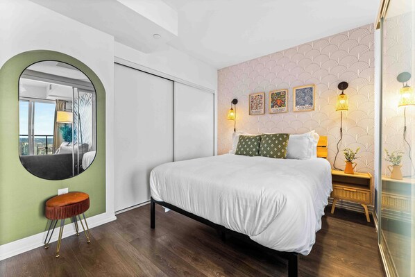 Tastefully designed bedroom with a queen bed and a full-length mirror