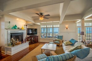 A cozy living room with a fireplace, plush seating, and charming coastal decor.