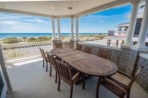 A covered porch with a large dining table and panoramic views, perfect for outdoor meals.