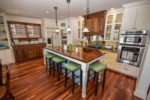 Modern kitchen with a central island, bar seating, and premium appliances for family meals.
