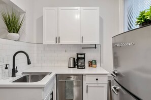 View of the kitchen with fridge and dishwasher, a true luxury in Beacon Hill!