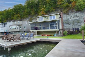Nestled at the edge of a serene lake, this charming dock features a row of inviting, comfortable chairs, perfect for relaxing and enjoying the peaceful surroundings. The chairs, crafted from weather-resistant materials, are designed for comfort with