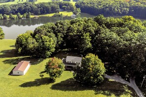 An expansive aerial view of the lakefront property, highlighting its proximity to the water and lush surroundings.